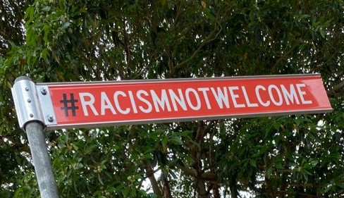 close up image of a red hash tag racism not welcome sign